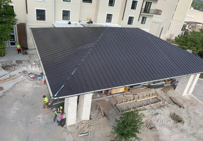 Metal roofing installation team working on a commercial building in Bloomfield